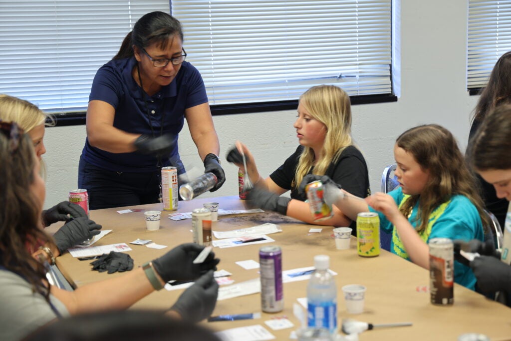Robyn Kainoa teaching girl scouts during fingerprint class at Kona police station.