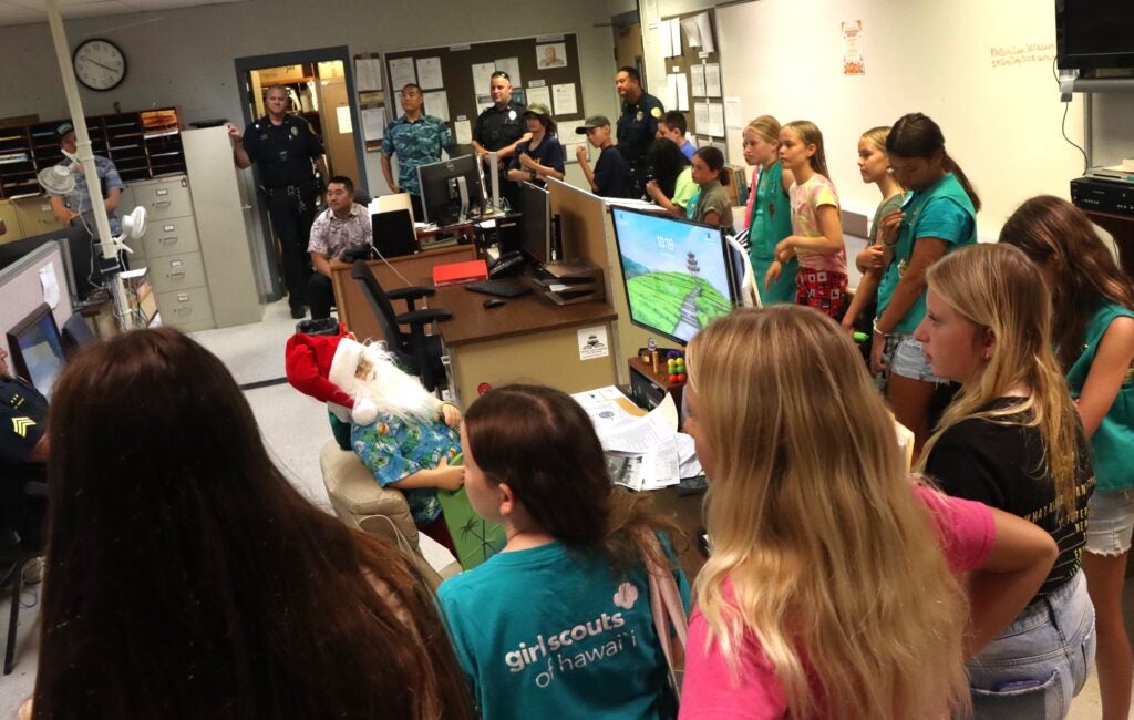 Scouts in CID room listening to detective speaking.