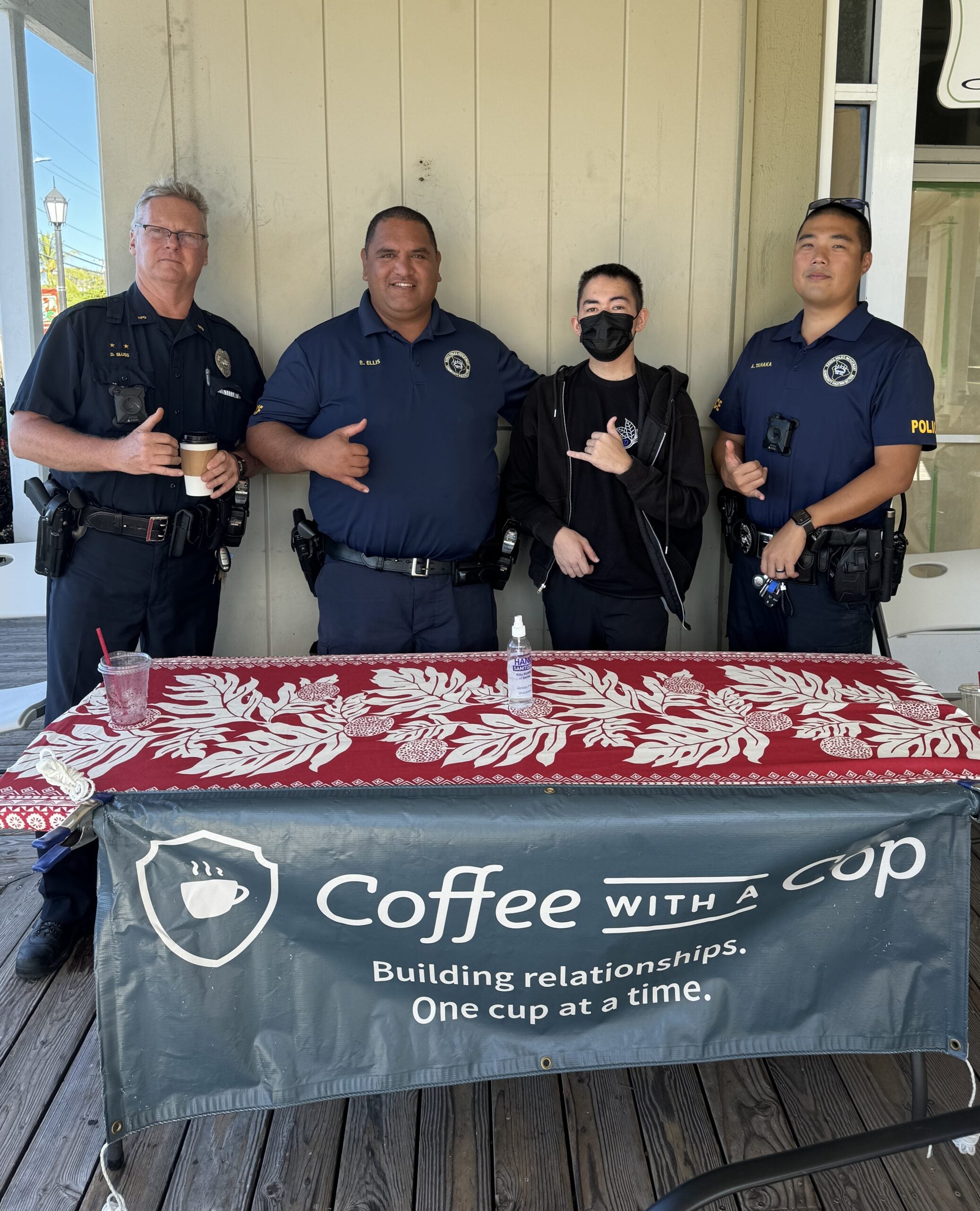 Three police officers with young man at Coffee With a Cop table.