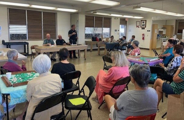 Officer Harvey speaking to group of senior citizens,.