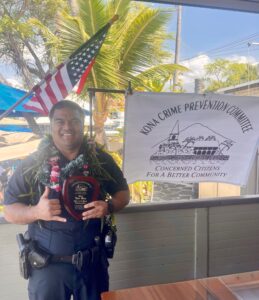 Kona Community Policing Officer Tyler Meno holding his Officer of the Month award.  