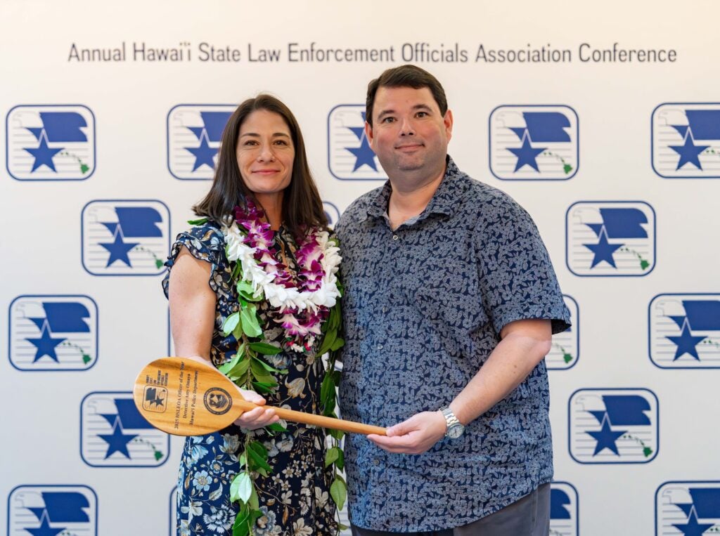 Sergeant Omaya holding award paddle standing ne Interim Chief Reed Mahuna. Award is for the 2025 Hawai‘i State Law Enforcement Officials Association (HSLEOA) Officer of the Year award. 