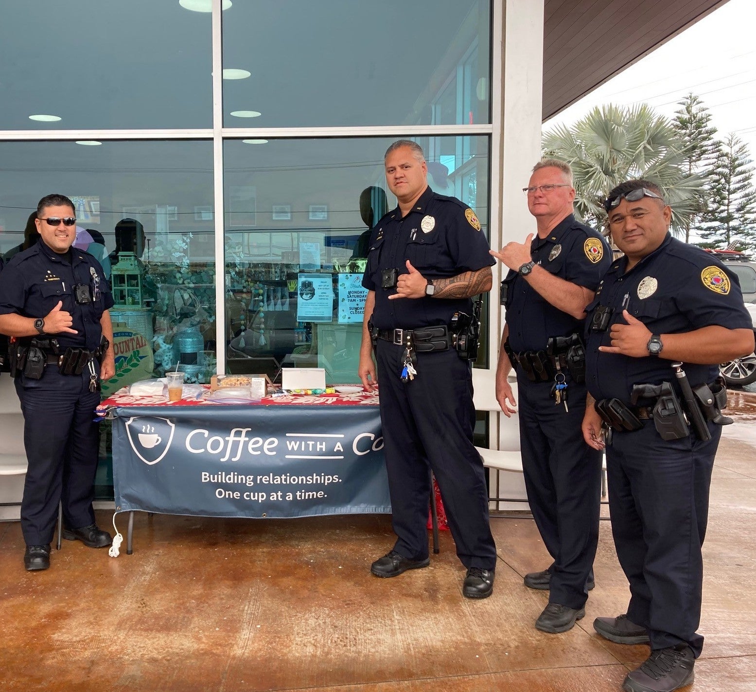 Officers standing by banner wat Kona Mountain Coffee Company