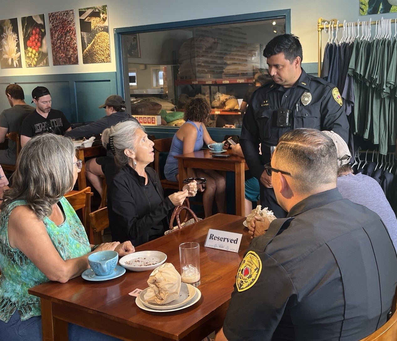 Two kupuna talking to two officers.