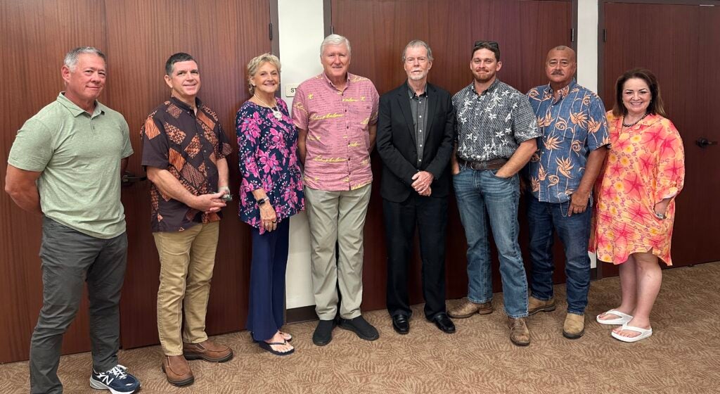 Eight members of the Hawaii County police commission standing in a row. 