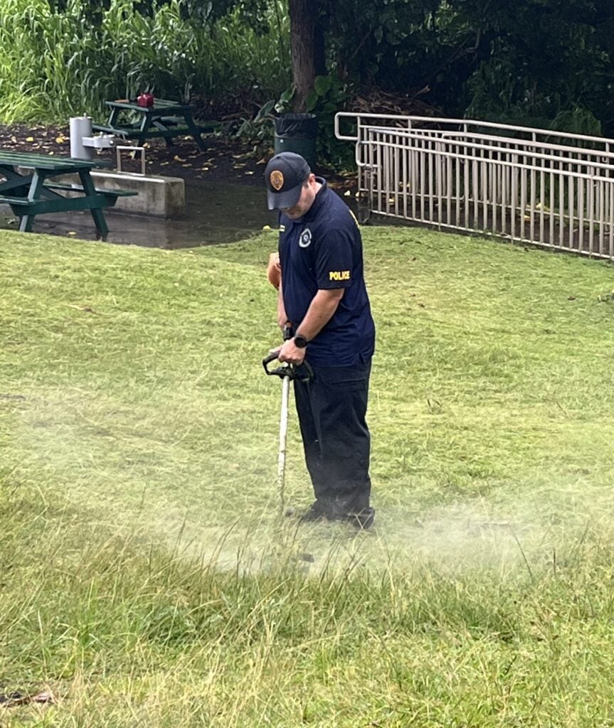 Officer Barto weed whacking at beach clean up.