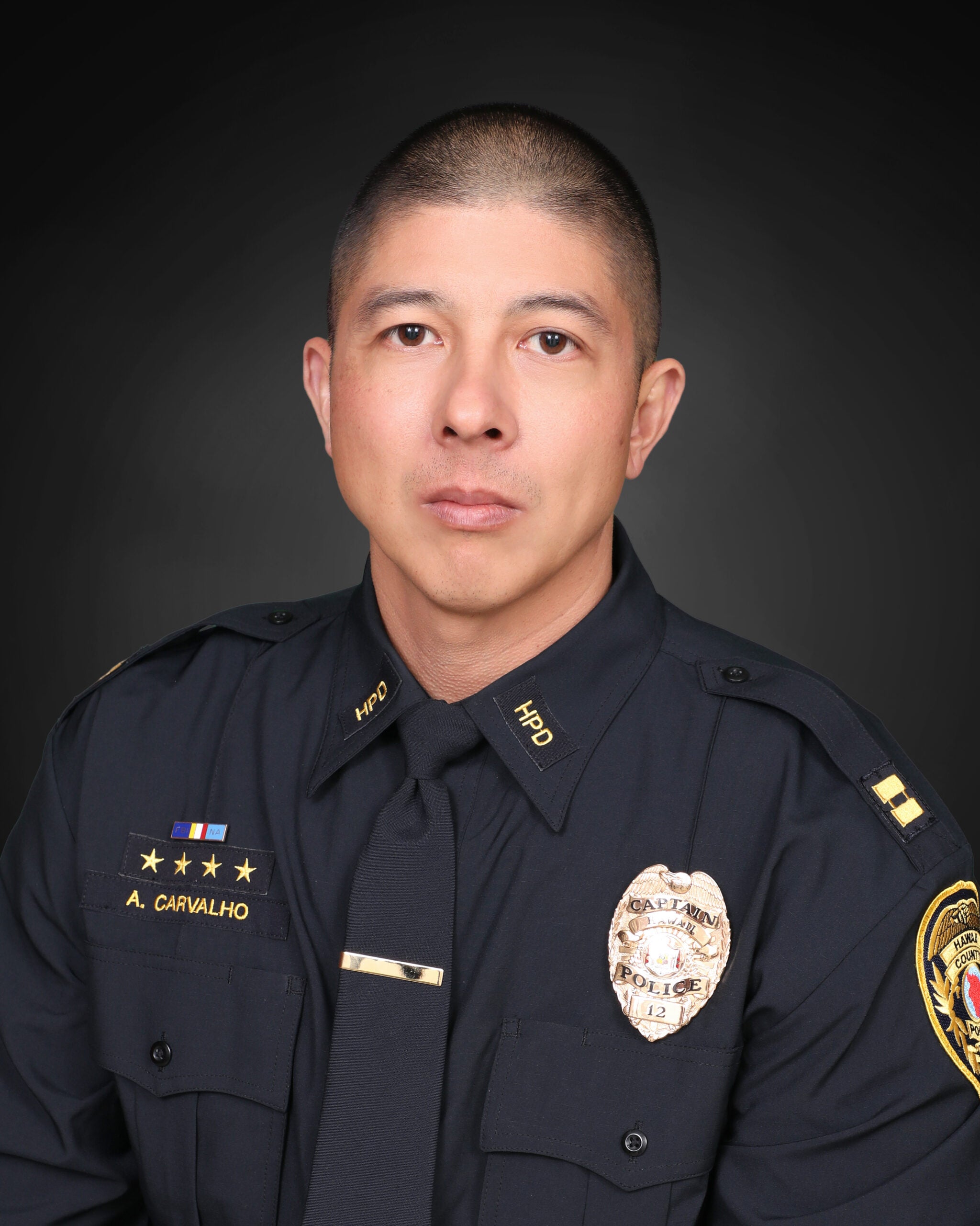 Captain Aaron Carvalho in uniform against a black background.