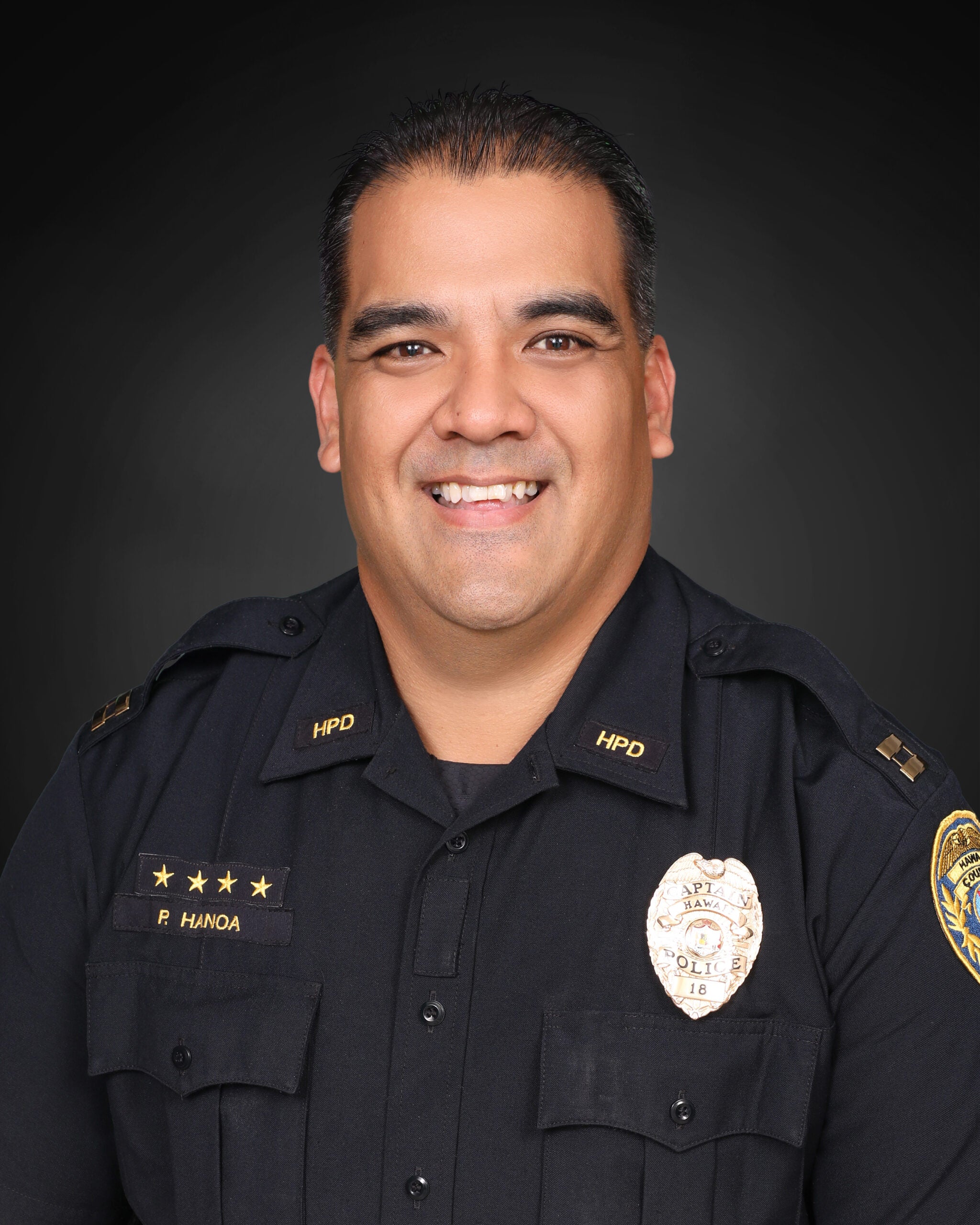 Captain Pernell Hanoa in uniform against a black background.