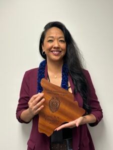 Cassie Fernandez holding her 2025 Dispatcher of the Year award.