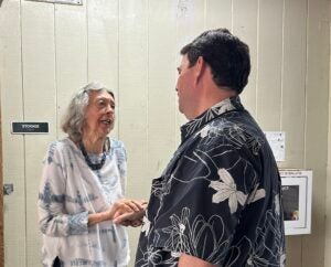 Chief Mahuna talking with elderly woman at community meeting. 