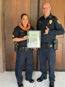 Detective Carrie Akina holding Haweo Award certificate next to Lt. Brandon Mansur.