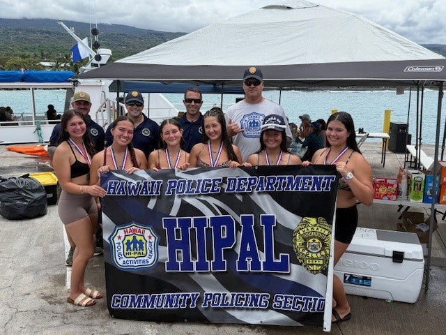Kai Opua Girls 18 under canoe racing team with police officers