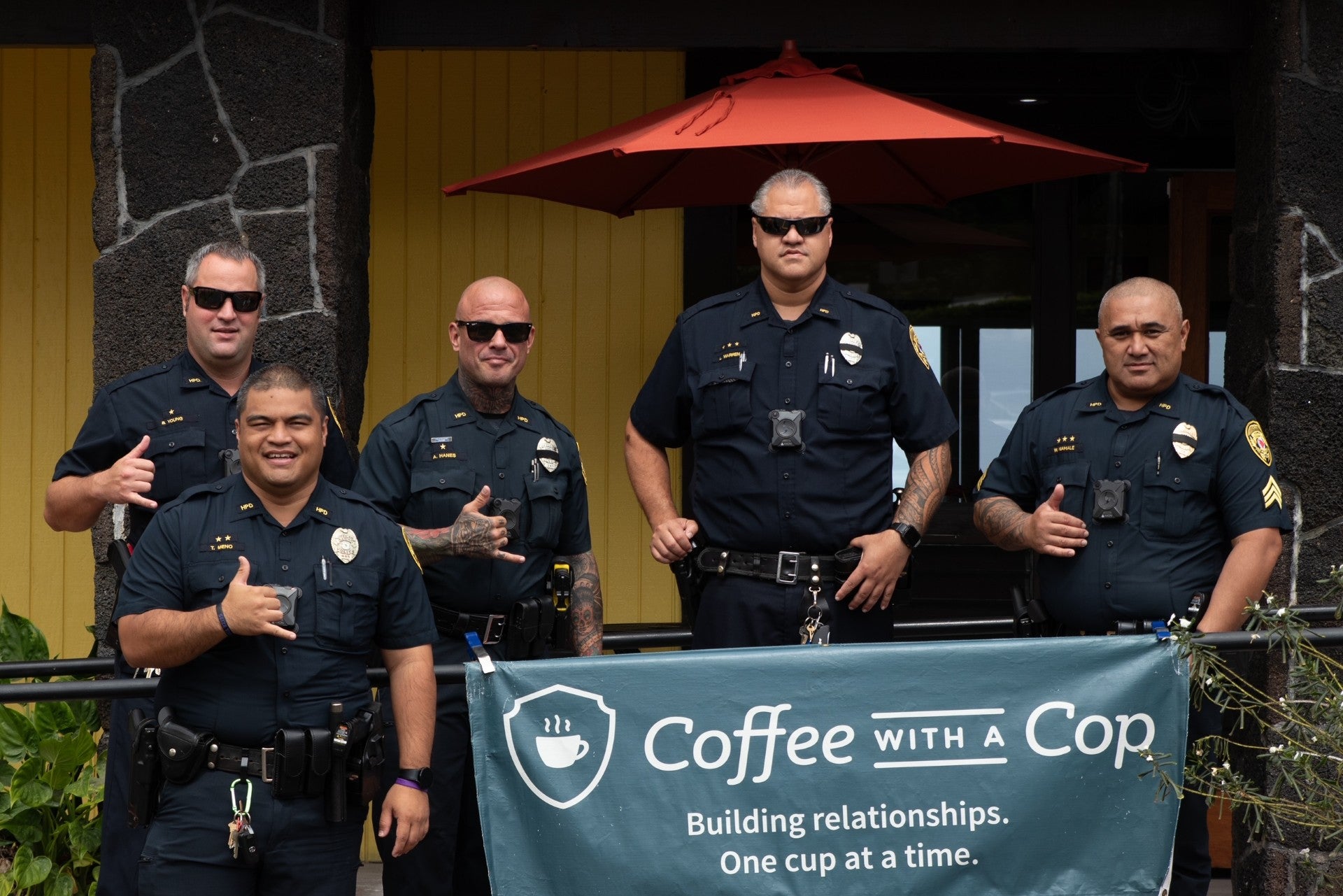 Five police officers standing behind Coffee With a Cop banner.