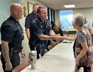Officer Harvey shaking woman's hand. 