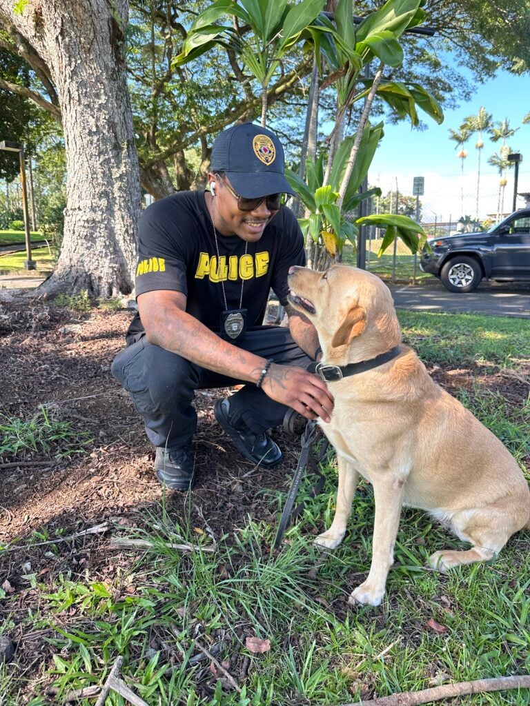Officer Christopher Ross & K9 Trina in front of tree.
