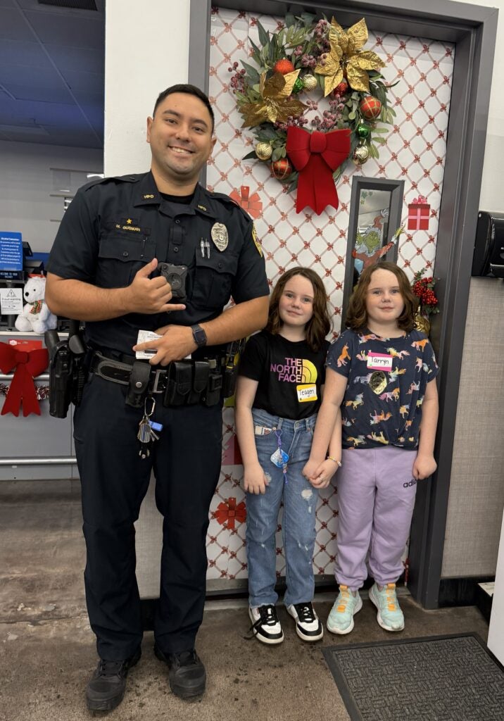 Officer with 2 young girls during Shop With a Cop.