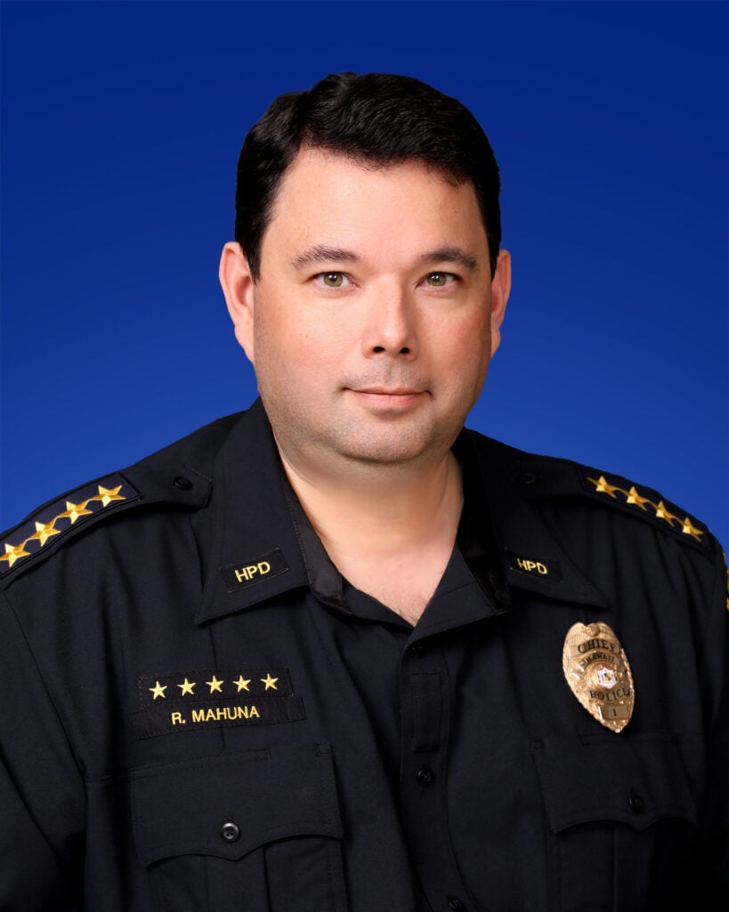 Police Chief Reed Mahuna in uniform with a blue background.