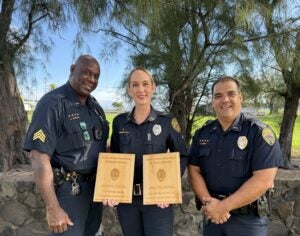 Sergeant Darrell Clinton and Captain Pernell Hanoa on either side of Officer Jenna Kosinski-Santos who was named 2025 Ka'u Officer of the Year and Ka'u Top Enforcer.