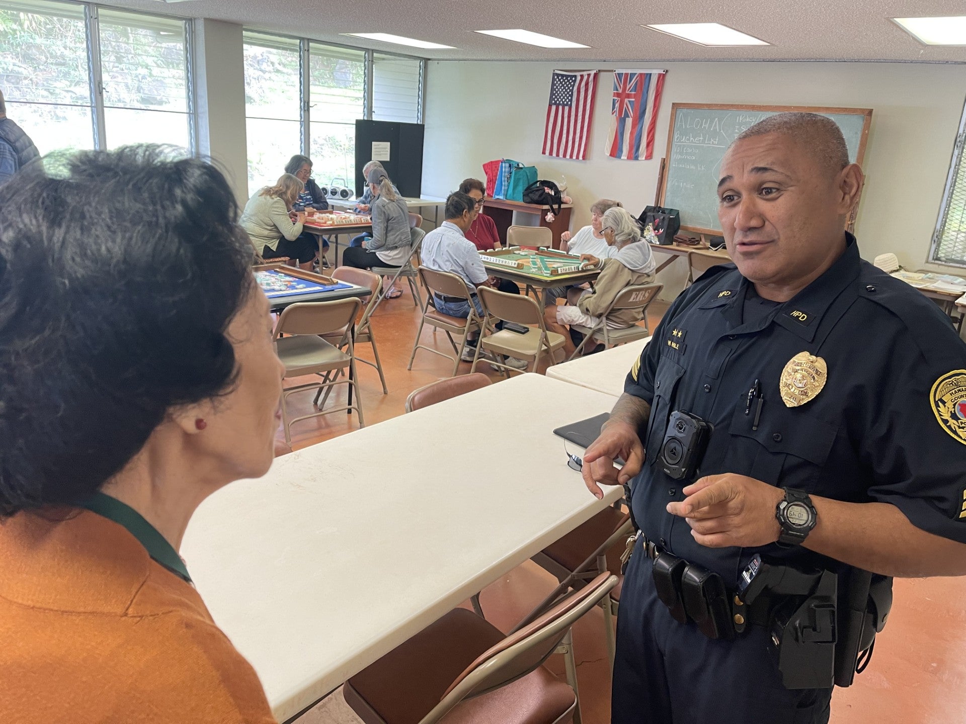 Sergeant Nahale with senior woman at Kupuna Watch meeting.