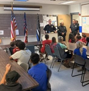 Junior Police Officers are gathered at the Kealakehe Police Station for a tour.