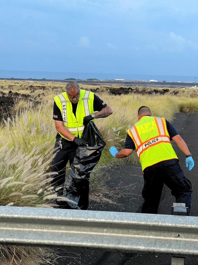 Two officers picking up trash during cleanup