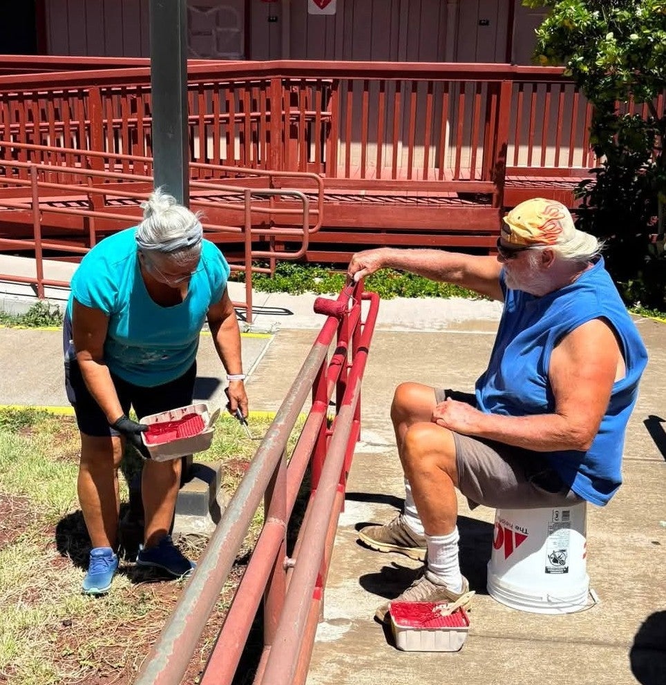 Volunteers painting railing