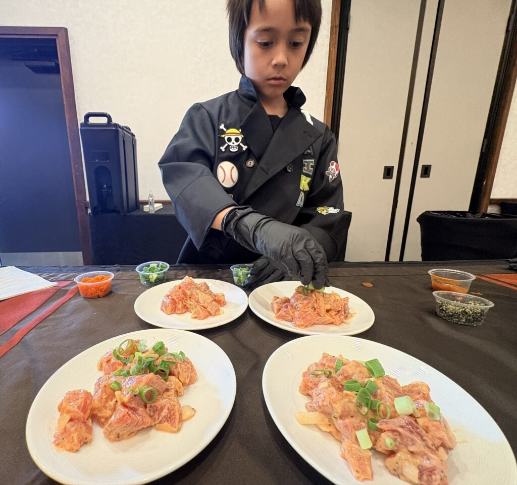 Young chef garnishing dishes