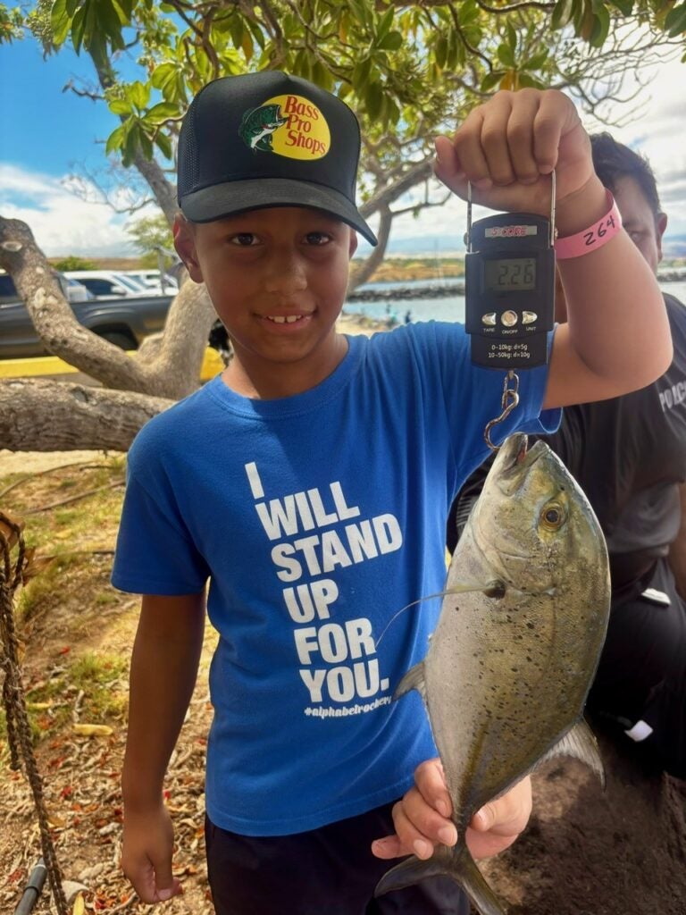 boy holding weighted fish