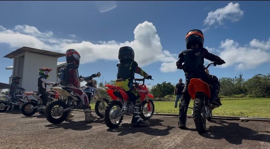 Young riders at starting line of motocross event.
